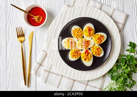 Festive appetizer: devilled eggs with a mix of egg yolks, sriracha sauce, mayonnaise, apple cider vinegar sprinkled with smoked paprika on a plate on Stock Photo