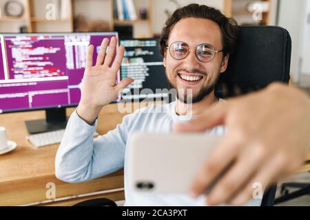 Image of unshaven joyful programmer man taking selfie photo and ...