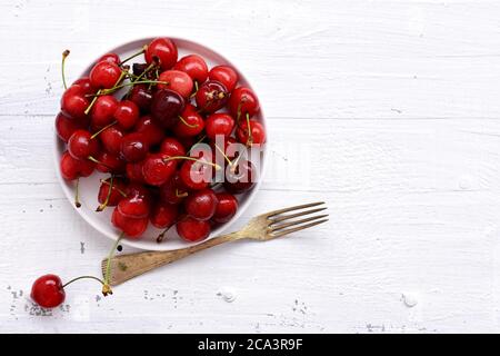 Fresh juicy red cherries isolated on white background/ red fresh cherries sweet cherry berries at white wooden background/ Closeup of cherries Stock Photo