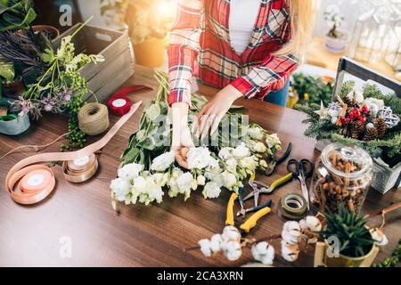 Hands of Caucasian woman wrapping bouquet in brown paper Stock