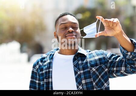 Portrait of afro man taking off mask and breathing Stock Photo