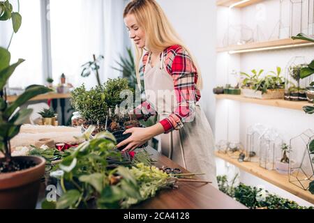 beautiful caucasian woman keen on flora and plants, enjoy working in flowers retail store or to have own shop of flowers. Stock Photo