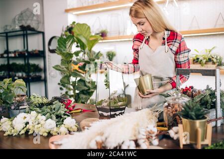 woman florist composing and creating wonderful bouquet of flowers, enjoy working in her own shop or garden. floral business concept