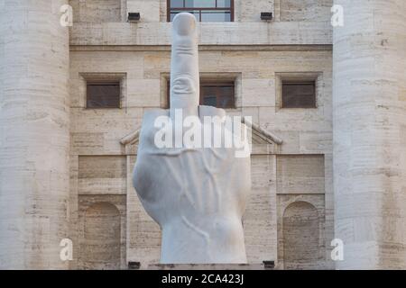 MILAN, ITALY - AUGUST 15, 2018: Maurizio Cattelan L.O.V.E. sculpture in Milan in Piazza degli Affari.. The sculpture, is  placed in front of midnight Stock Photo