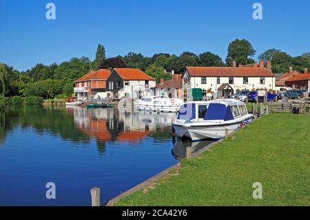 A bend in the River Bure with moored boats by the Rising Sun public house on the Norfolk Broads at Coltishall, Norfolk, England, United Kingdom. Stock Photo