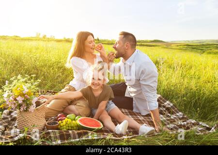 Young woman feeding her man with grape Stock Photo