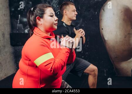 plump pleasant woman is concentrated on her workout. close up side view photo. much effort for health Stock Photo