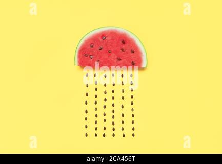 Watermelon slice with seeds on yellow background. food art. Flat lay