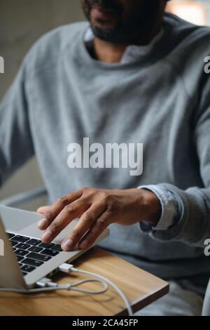 Close up adult casual businessman intently working on laptop indoor Stock Photo