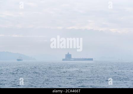 An 1100 tonne Sydney-Manly Ferry and Fort Denison in Sydney Harbour almost disappear in a morning that has blanketed the city in an Australian winter Stock Photo