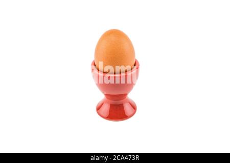 Ceramic red egg cup with brown egg isolated on white background. Stock Photo