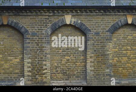 ancient wall of a cemetry with pattern of a doorway forming a pattern Stock Photo