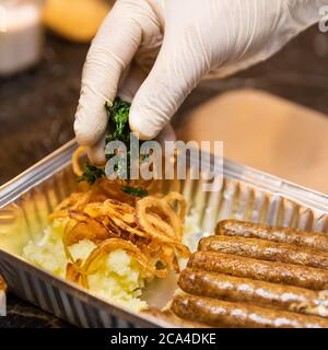 Chef putting greens on the German sausages Stock Photo