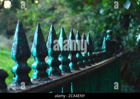 green cast iron fence with pointy end with some parts in focus Stock Photo