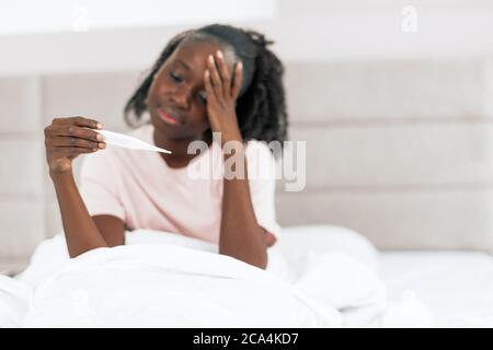unhappy sick girl with a thermometer. blurred image. focus on the thermometer. tool , equipment. copy space Stock Photo