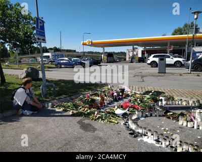 Stockholm. 4th Aug, 2020. Local people gather and mourn near to the site where a 12-year-old girl was killed after being hit by a stray bullet in a gang shooting at a petrol station car park in Norsborg, south of Stockholm, Sweden, Aug. 4, 2020. Sweden's Minister for Home Affairs Mikael Damberg vowed on Tuesday to tackle gang-related crimes following the recent tragic death of a 12-year-old girl. According to Swedish Television, the shooting was part of an escalating conflict between gangs fighting over local drug markets. Credit: Xinhua/Alamy Live News Stock Photo