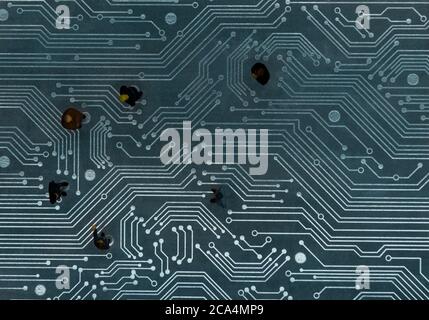 Miniature figurines posed as business people in a meeting over abstract futuristic circuit board, future business concept Stock Photo