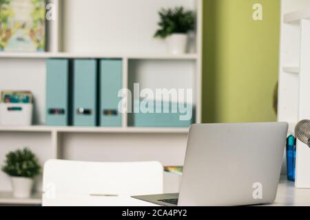 Office desk with laptop on table. Workspace with nobody. Copy space with blurry background Stock Photo