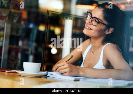 Beautiful young student with lots of books, studying or preparing for exams Stock Photo