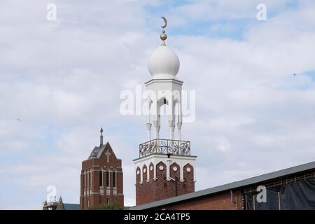 Birmingham Central Mosque stands before St Alban the Martyr, Birmingham, a Grade II listed Church of England parish church in Highgate, on 3rd August 2020 in Birmingham, United Kingdom. Birmingham Central Mosque is one of the earliest purpose-built mosques in the UK, and is run by the Birmingham Mosque Trust. The organization, Muslims in Britain classify the Birmingham Central Mosque as, hanafi sunni, and has a capacity of 6,000, including women. Stock Photo