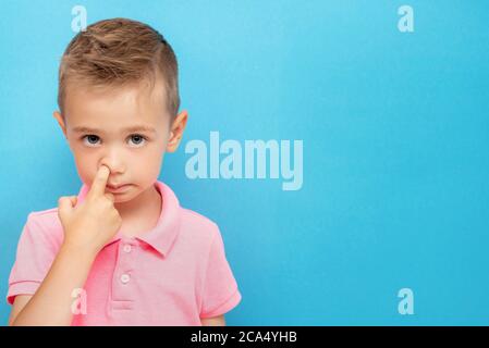 Little kid picks up in his nose. bad habits concept Stock Photo