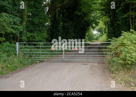 Locked farmers heavy duty agriculture gates to an old disused road. Stock Photo