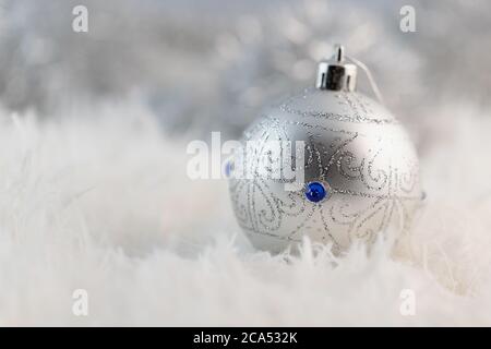 poster with one silver Christmas ball on white fluffy fur background Stock Photo