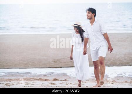Happy young couple walk on the beach on honeymoon. Stock Photo