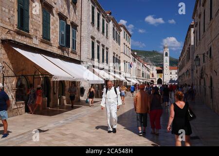 DUBROVNIK, CROATIA - JULY 26, 2019: Tourists visit Stradun shopping street paved with polished limestone in Dubrovnik Old Town, a UNESCO World Heritag Stock Photo