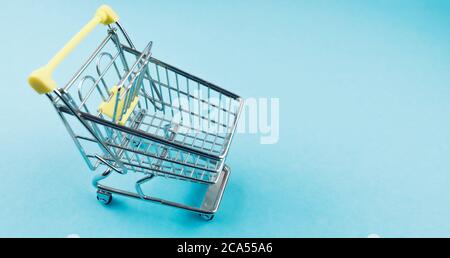 high angle view of miniature shopping cart on blue background Stock Photo