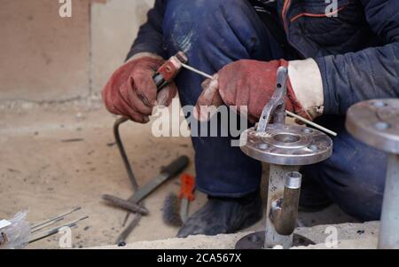 Close-up welder working with electrode at semi-automatic arc welding in manufacture production plant Stock Photo