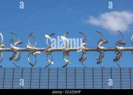 Restricted area.  Close up of barbed wire security fence against a blue sky Stock Photo