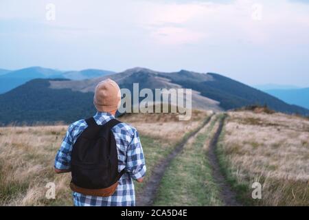 Man with backpack on mountains road. Travel concept. Landscape photography Stock Photo