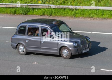 2010 grey London Taxis Int TX4 Bronze; Vehicular traffic moving vehicles, cars driving vehicle on UK roads, motors, motoring on the M6 motorway highway network. Stock Photo