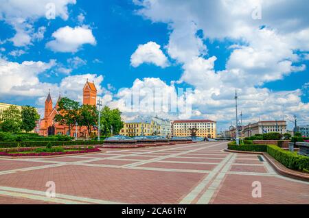 Independence Square in Minsk city centre with Saints Simon and Helena Roman Catholic church or Red Church and Minsk Hotel building, blue sky white clouds in sunny summer day, Republic of Belarus Stock Photo