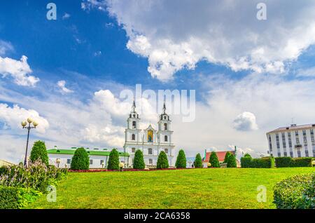 Holy Spirit Cathedral Orthodox Church Baroque style building and green grass lawn in Upper Town Minsk historical city centre, blue sky white clouds in sunny summer day, Republic of Belarus Stock Photo