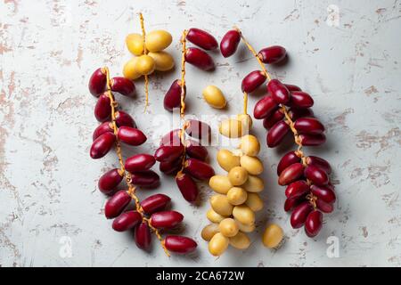 red and yellow fresh dates fruit on white background Stock Photo