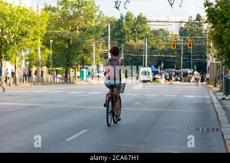 Sofia, Bulgaria. 3rd August 2020.  Lone girl on bicycle on closed street in Sofia Bulgaria as the anti-Government peaceful protests against corruption intensify across the country for the last 26 days with some major streets and intersections around the parliament building blocked by tents and barricades and the capital city centre is totally closed for transport. Credit: Ognyan Yosifov / Alamy News Stock Photo