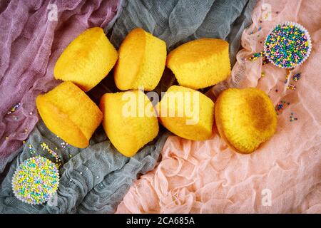 Freshly baked cupcakes with colorful sprinkles. Top view. Stock Photo