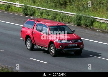 A 2012 Mitsubishi L200 Trojan Dcb Di-D 4X4 Red LCV Double Cab Pick Up driving on the M6 motorway near Preston in Lancashire, UK Stock Photo