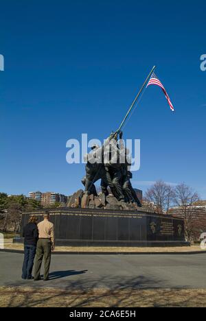 A soldier and his spouse standing in front of the United States Marine Corps War Memorial on a winter day Stock Photo