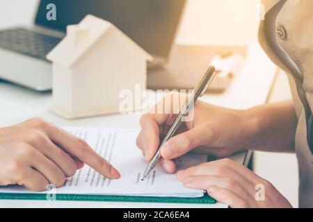 Client Signs Document to Buy House and Real Estate Stock Photo