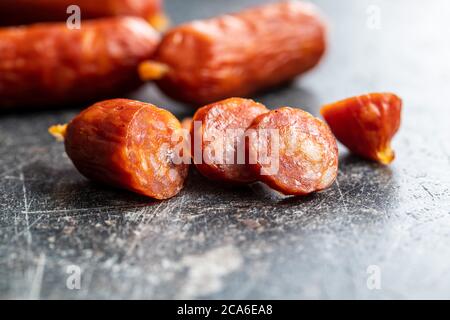 Sliced mini salami sausages on black table. Stock Photo