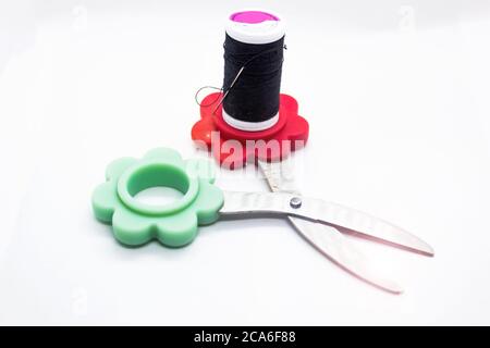 A needle, black thread and scissor for sewing against white background representing better together concept under object love photography Stock Photo