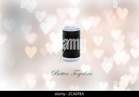 A needle and black thread for sewing against heart bokeh background representing better together concept under object love photography Stock Photo
