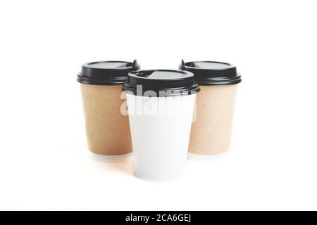 Three eco friendly paper craft cups for coffee with black lid on the white background. Zero waste, plastic free concept. Sustainable lifestyle. Compos Stock Photo