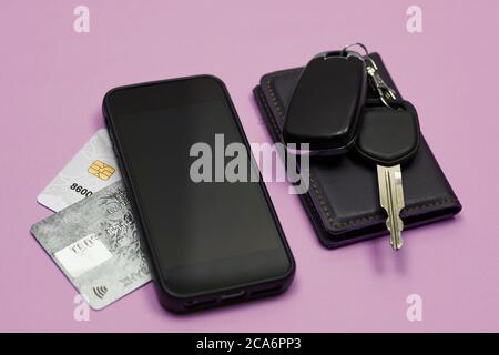Car keys, mobile phone and credit cards on blue background. Top view. Do not forget to take car keys, money and smartphone before leaving home Stock Photo