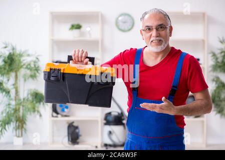 Old repairman repairing appliances in his workshop Stock Photo