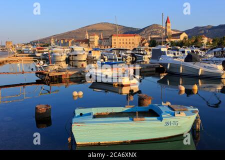 Small motorboats moored near the beautiful Cathedral of Saint Lawrence, Camerlengo Castle and other landmarks in Trogir, Croatia Stock Photo