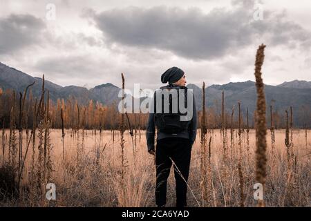 man standing in the field in front of mountains Stock Photo